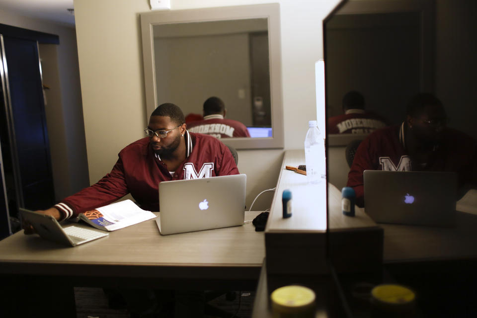 In this Tuesday, May 5, 2020, photo, Morehouse College senior Lanarion "LTL" Norwood Jr., of Atlanta, works on his computer in a hotel room in Atlanta. Students were sent home from the college amid the new coronavirus outbreak. Norwood learned the campus was shutting down and he was worried about going home to finish his senior year in a neighborhood he describes as "gang-ridden, drug-ridden, all over violence-ridden." Morehouse stepped up with a plan, working to house about 20 students. (AP Photo/Brynn Anderson)