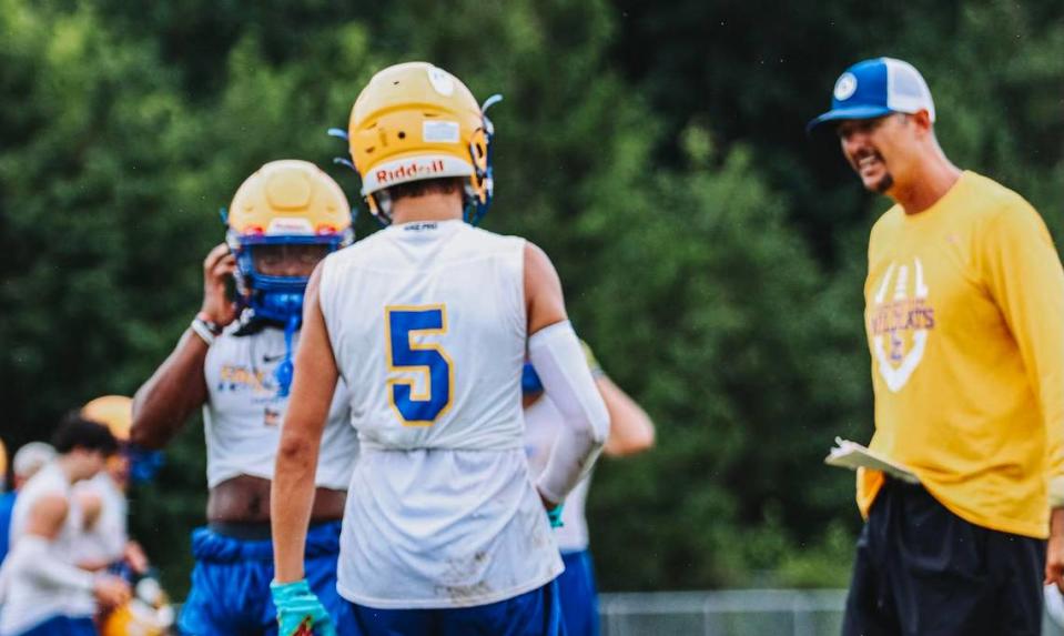 Lexington coach Perry Woolbright, right, talks to his son Brayden during a 7-on-7 this summer against Camden.