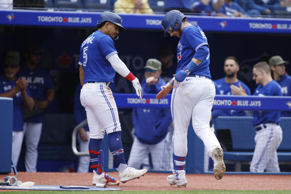 Toronto Blue Jays' Danny Jansen (9) celebrates a solo home run with Santiago Espinal (5) in the sixth inning of a baseball game against the Baltimore Orioles in Toronto, Saturday, May 20, 2023. (Cole Burston/The Canadian Press via AP)