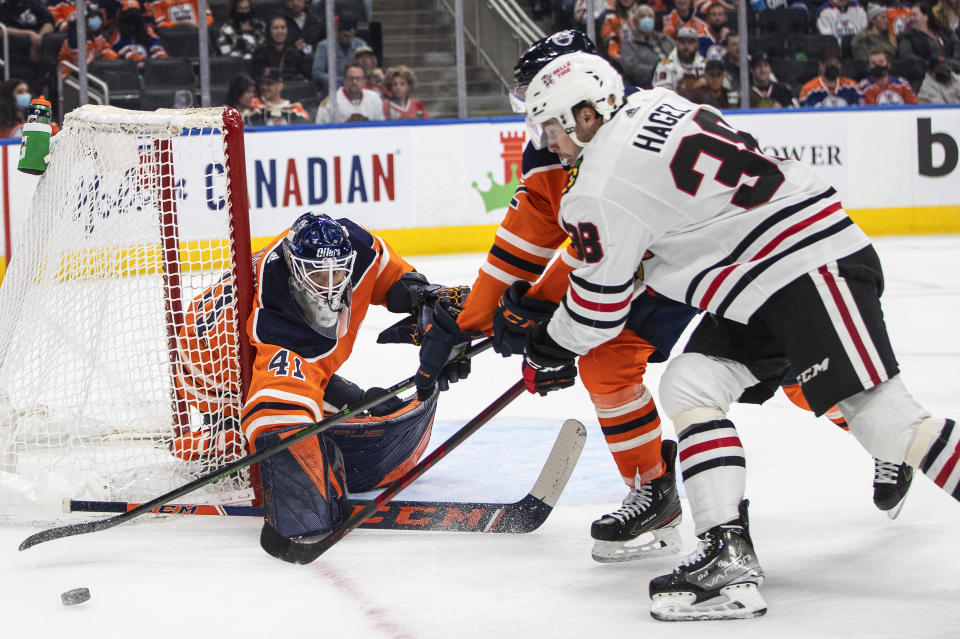 Chicago Blackhawks' Brandon Hagel (38) is stopped by Edmonton Oilers goalie Mike Smith (41) during the third period of an NHL hockey game Wednesday, Feb. 9, 2022, in Edmonton, Alberta. (Jason Franson/The Canadian Press via AP)