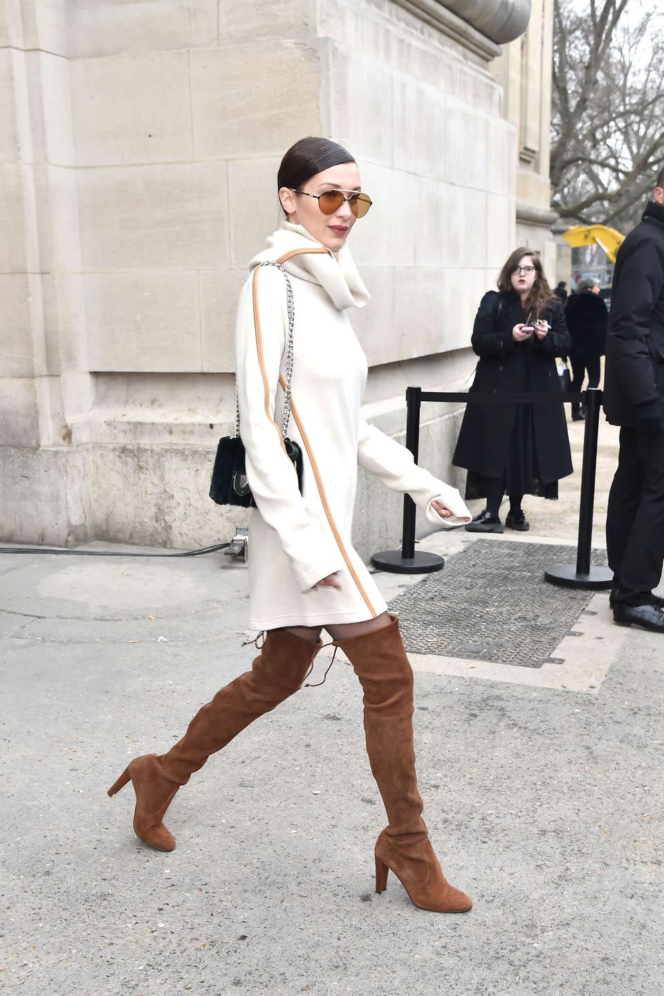 <p>In a Céline cream cowl neck sweater dress, Stuart Weitzman suede over-the-knee boots, Carrera aviator sunglasses and fur bag while leaving the Chanel couture show in Paris.</p>