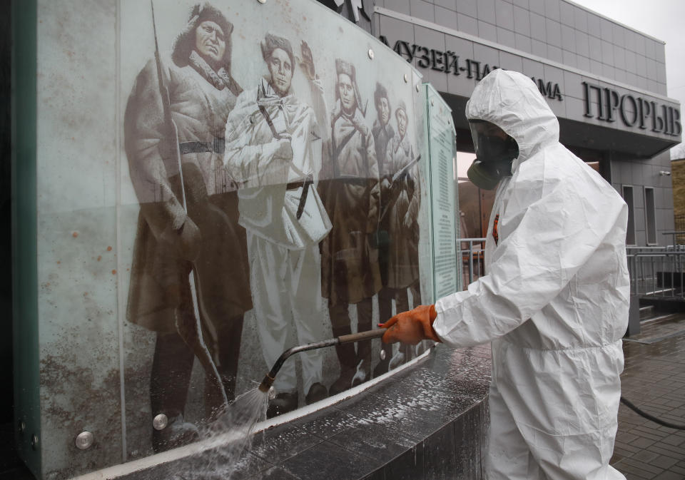 A specialist from a local veterinary service wears a protective suit as sprays disinfectant near at the Proryv (The Breakthrough) museum dedicated to the breakthrough of the Siege of Leningrad during World WarII near Kirovsk, about 30 kilometres (19 miles) east of St.Petersburg, Russia, Thursday, April 2, 2020. The new coronavirus causes mild or moderate symptoms for most people, but for some, especially older adults and people with existing health problems, it can cause more severe illness or death. (AP Photo/Dmitri Lovetsky)