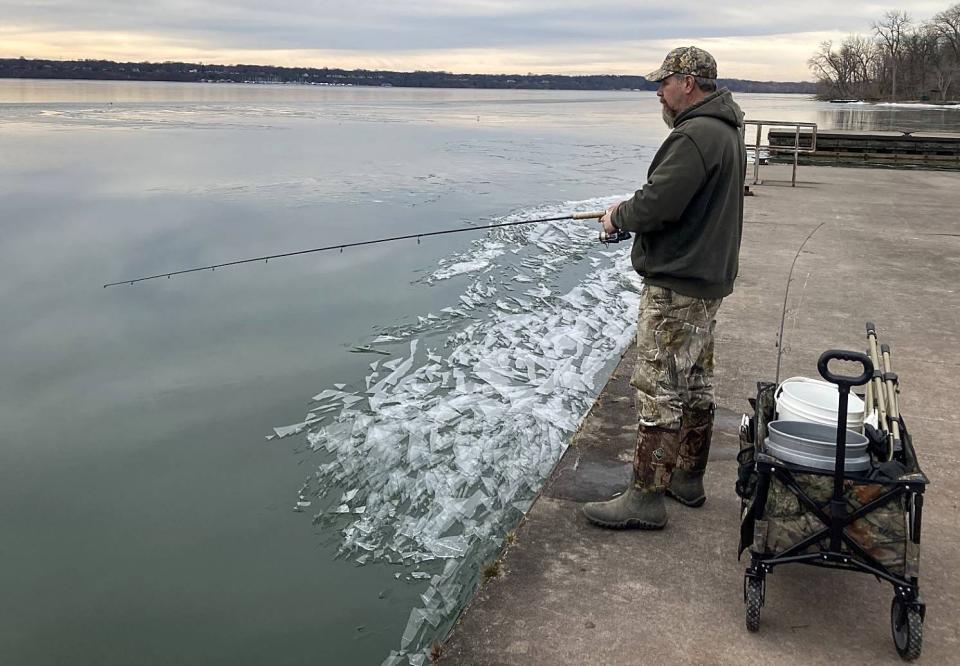 Joe Muto, 58, of Millcreek Township., casts for perch Feb. 8 while fishing at Presque Isle State Park's Waterworks Ferry Dock. A lack of ice on Presque Isle Bay has allowed people to fish along the shore this winter.