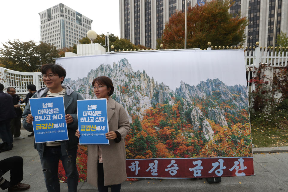Protesters pose with an image of North Korea's Diamond Mountain during a rally calling for the resumption of Diamond Mountain tourism in Seoul, South Korea, Monday, Oct. 28, 2019. South Korea on Monday proposed a face-to-face meeting with North Korea on the fate of a long-shuttered joint tourist project at a scenic North Korean mountain, as their relations remain cool over stalemated nuclear diplomacy. The sign reads "North and South Korean college students want to meet at Kumgang Mountain, Diamond Mountain!"( AP Photo/Ahn Young-joon)