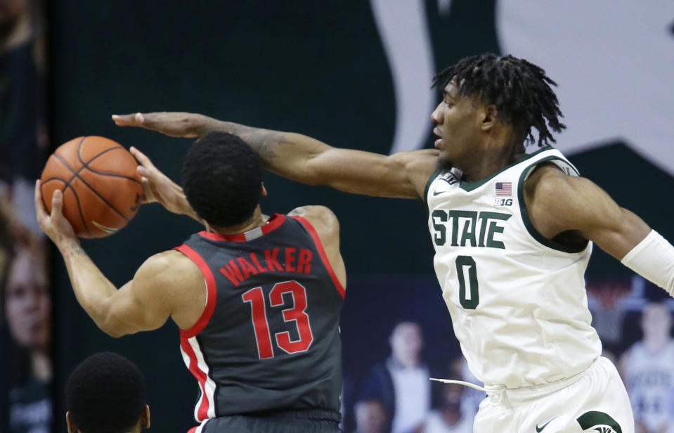 Michigan State forward Aaron Henry (0) defends against a shot by Ohio State guard CJ Walker (13) during the second half of an NCAA college basketball game Thursday, Feb. 25, 2021, in East Lansing, Mich. (AP Photo/Duane Burleson)