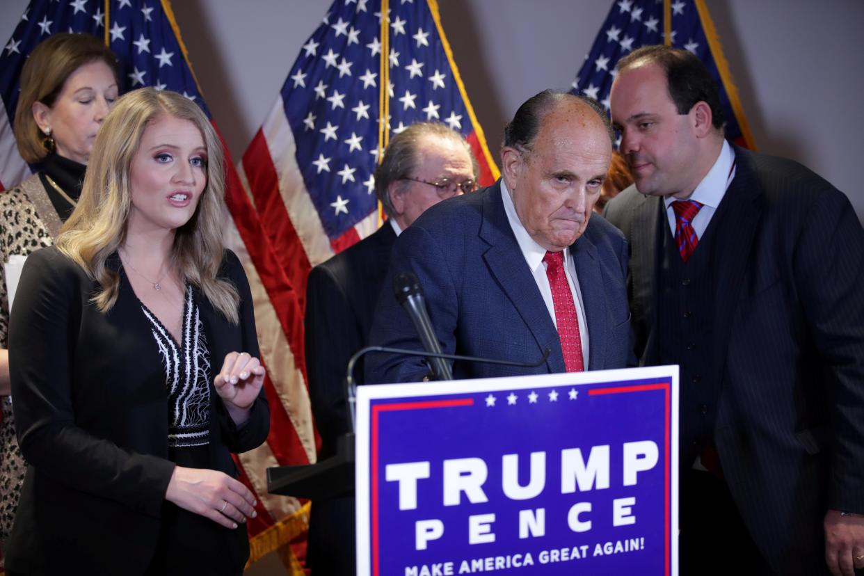 <p>Trump campaign adviser Boris Epshteyn whispers Rudy Giuliani during a news conference at Republican National Committee headquarters in Washington DC on 19 November.</p> (REUTERS)