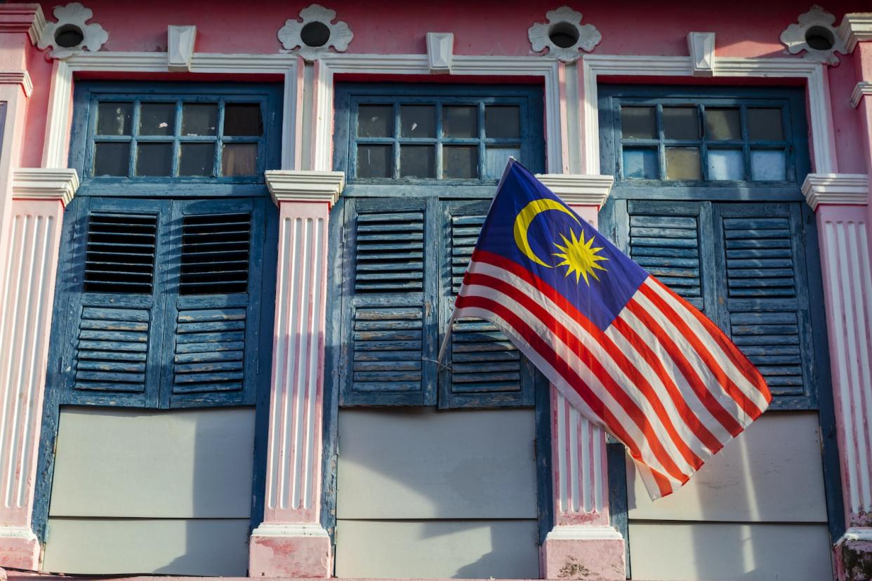 A photo of the Malaysia flag hooked on to a building.