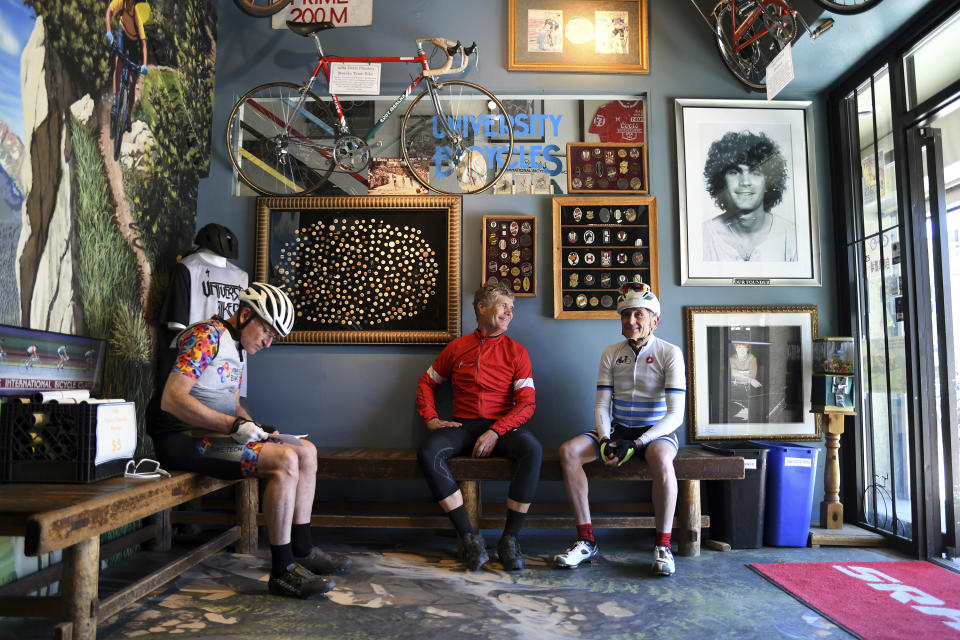 University Bicycles owner Douglas Emerson, center, talks with friends in his shop in Boulder, Colo., on Tuesday, April 30, 2024. Bike stores quickly sold out of their stock early in the pandemic and had trouble restocking because of supply chain issues. Now, inventory is back, but demand has waned. (AP Photo/Thomas Peipert)