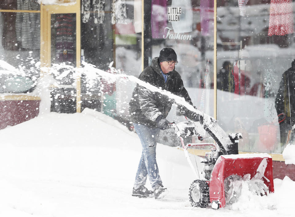 John Strokowski plows snow off a sidewalk outside in Buffalo, N.Y.'s Elmwood Village on Monday, Dec. 26, 2022. Clean up is currently under way after a blizzard hit four Western New York counties. (Joseph Cooke/The Buffalo News via AP)