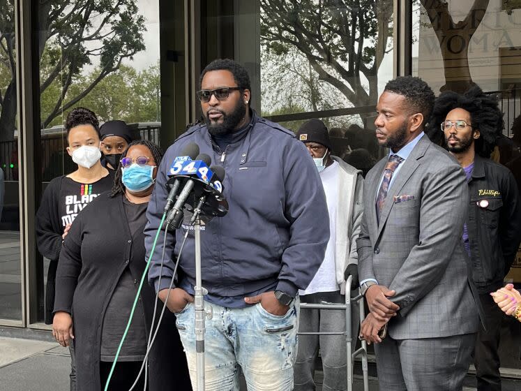 Terrell Traylor (center) speaks about the killing of his nephew, Christopher Deandre Mitchell