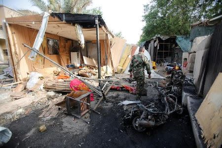 A member of Iraqi security forces inspects the site after a suicide car bomb attack in Baghdad, Iraq April 29, 2017. REUTERS/Khalid al Mousily