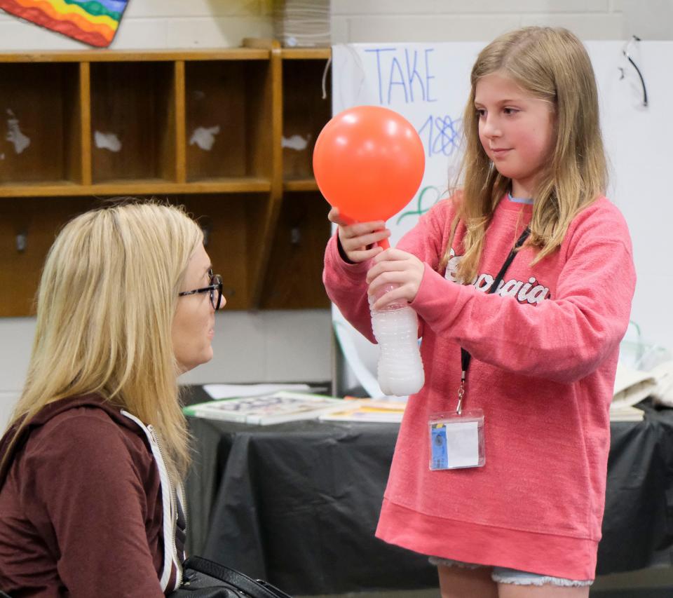 Students make presentations to their parents on all they have learned during the SEW camp at Verner Elementary School Friday, June 23, 2023. Emerson Guyotte demonstrates how a chemical reaction in a bottle can inflate a balloon in the kitchen science demonstration. 