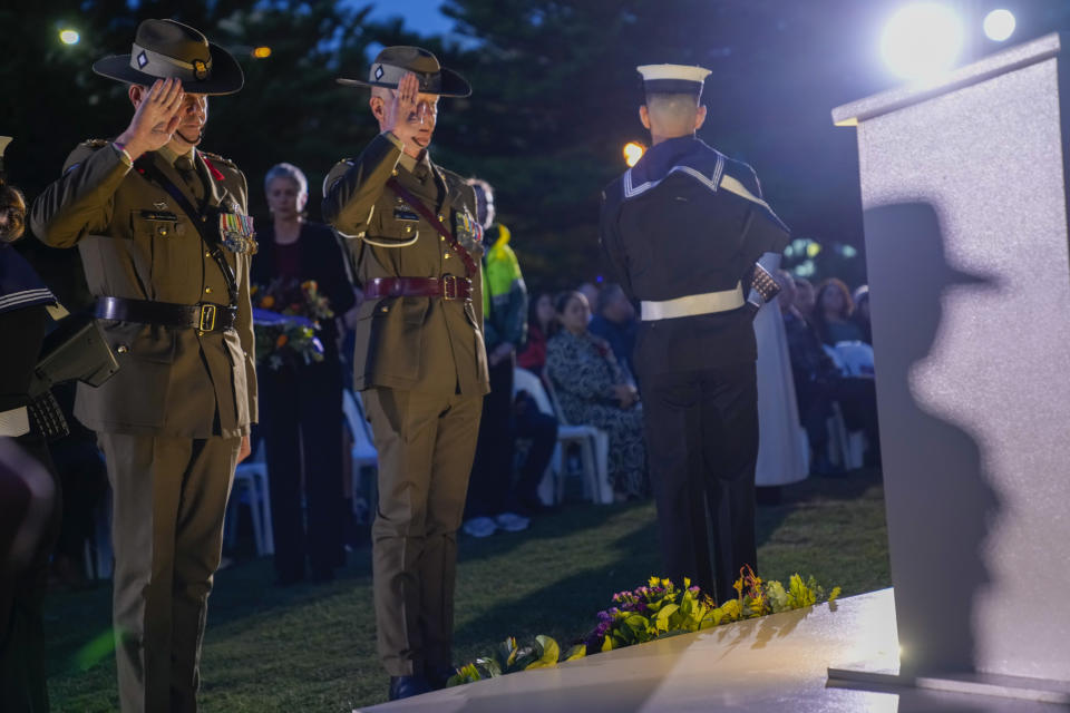 Soldiers salute after laying a wreath during an Anzac Day dawn service at Coogee Beach in Sydney, Australia, Thursday, April 25, 2024. (AP Photo/Mark Baker)