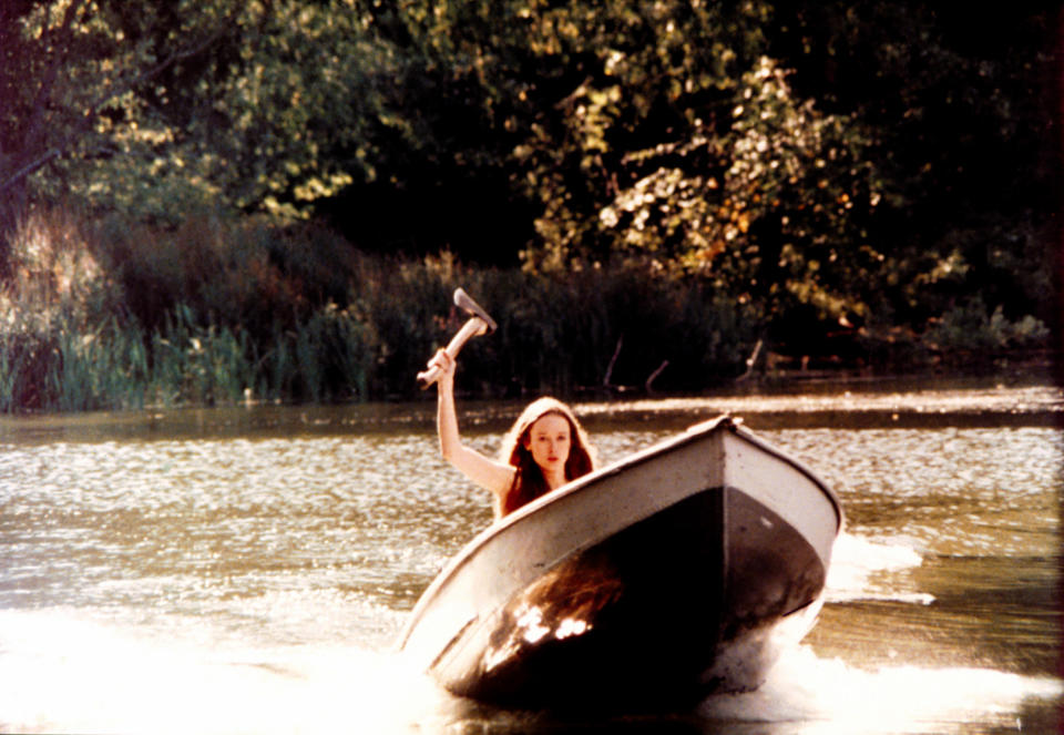 A woman with an axe rides in a boat