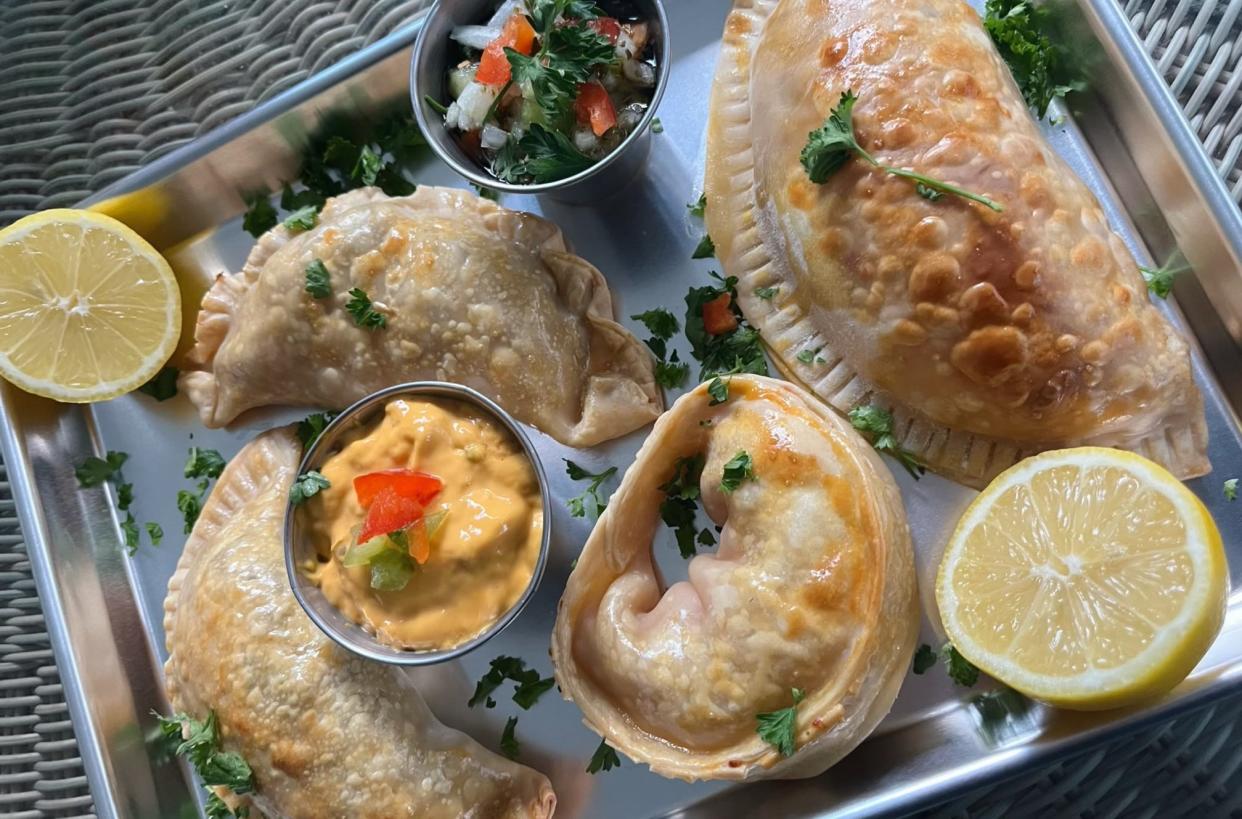 Chicken, tenderloin, jamόn y queso, and pulled pork and cheddar empanadas alongside queso and chimichurri dipping sauces from Wake Up Café in New Smyrna Beach.