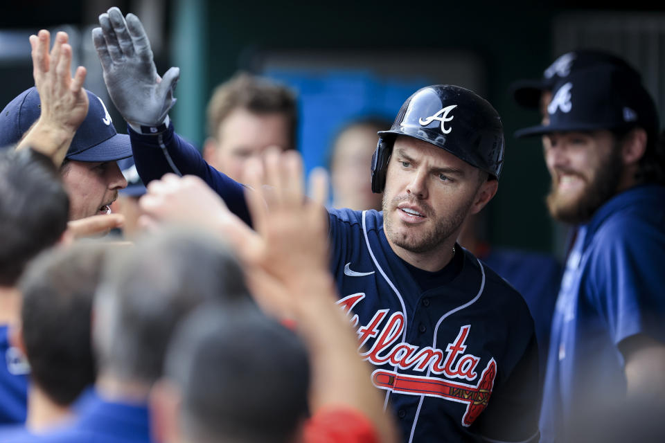 Atlanta Braves' Freddie Freeman high-fives teammates in the dugout after hitting a solo home run during the first inning of a baseball game against the Cincinnati Reds in Cincinnati, Thursday, June 24, 2021. (AP Photo/Aaron Doster)