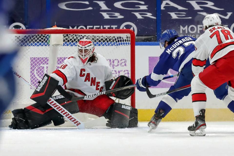 Carolina Hurricanes goaltender Alex Nedeljkovic makes a pad save on a shot from Tampa Bay Lightning’s Ryan McDonagh as Steven Lorentz (78) defends during the first period of an NHL hockey game Tuesday, April 20, 2021, in Tampa, Fla. (AP Photo/Mike Carlson)