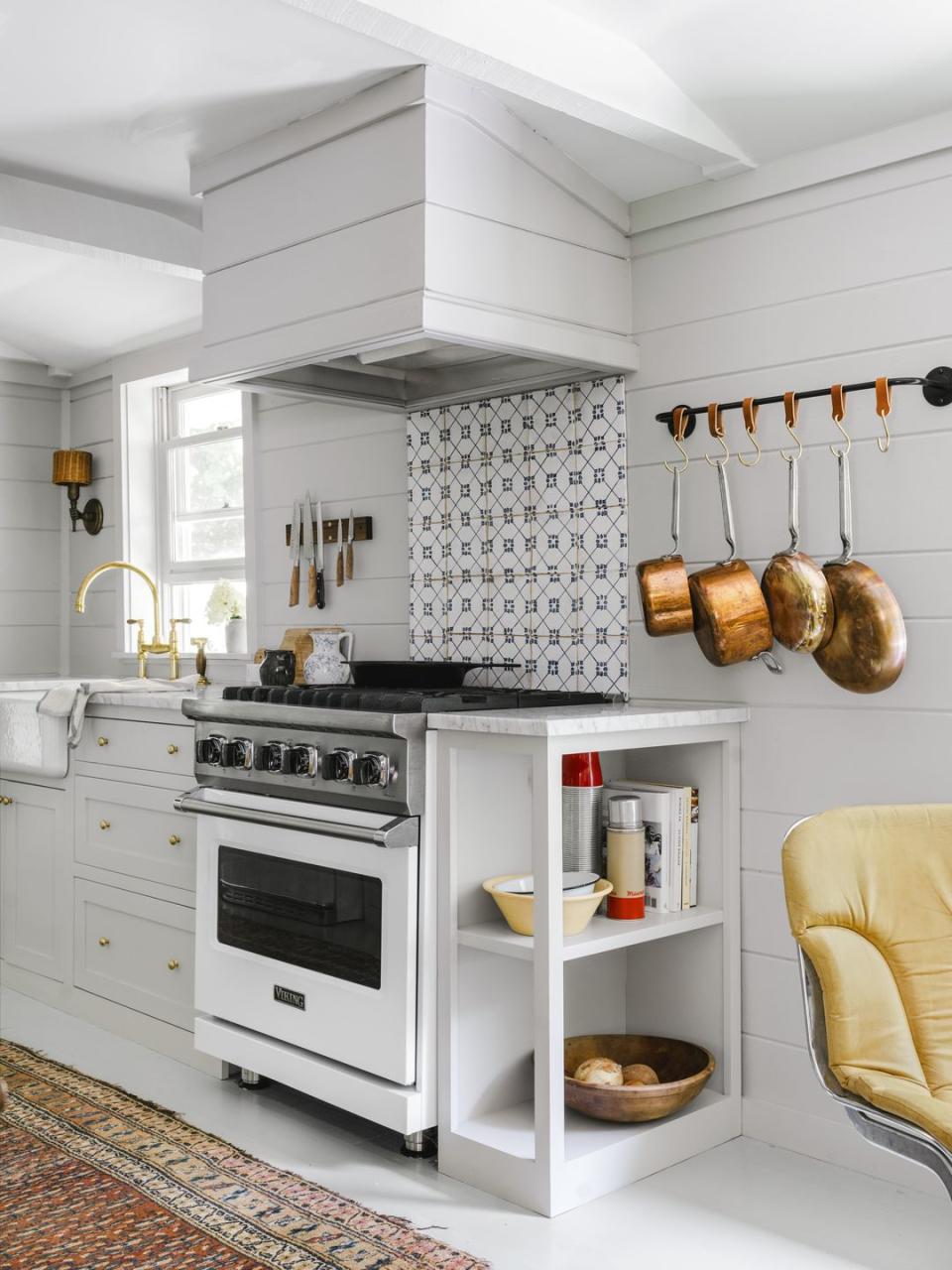 small all white galley kitchen with a graphic tile backsplash