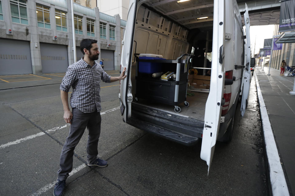 In this Jan. 14, 2020 photo, Chris Hill closes a van door carrying a cooler containing a piece of live brain tissue for transport from Harborview Medical Center in Seattle to the Allen Institute after the tissue was donated by Genette Hofmann as she underwent brain surgery for epileptic seizures that had disrupted her life for decades. As part of the surgery, Hofmann agreed to donate a small bit of her healthy brain tissue to researchers at the Allen Institute, who were eager to study brain cells while they were still alive. (AP Photo/Ted S. Warren)