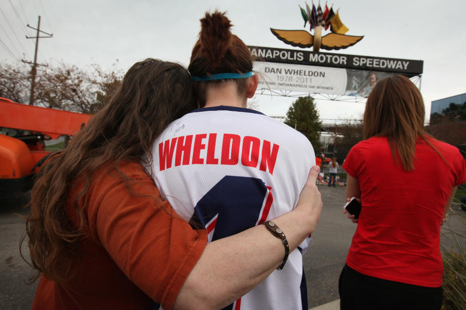 INDIANAPOLIS, IN - OCTOBER 17: Deann Klotzsche (L), Katie Mitchell (C) and Kelley Bennett comfort each other as they view a memorial to two-time Indianapolis 500 winner Dan Wheldon at the gate of the Indianapolis Motor Speedway on October 17, 2011 in Indianapolis, Indiana. Wheldon, winner of the 2005 and 2011 Indy 500 races, was killed in a crash yesterday at the Izod IndyCar series season finale at Las Vegas Motor Speedway. (Photo by Scott Olson/Getty Images)