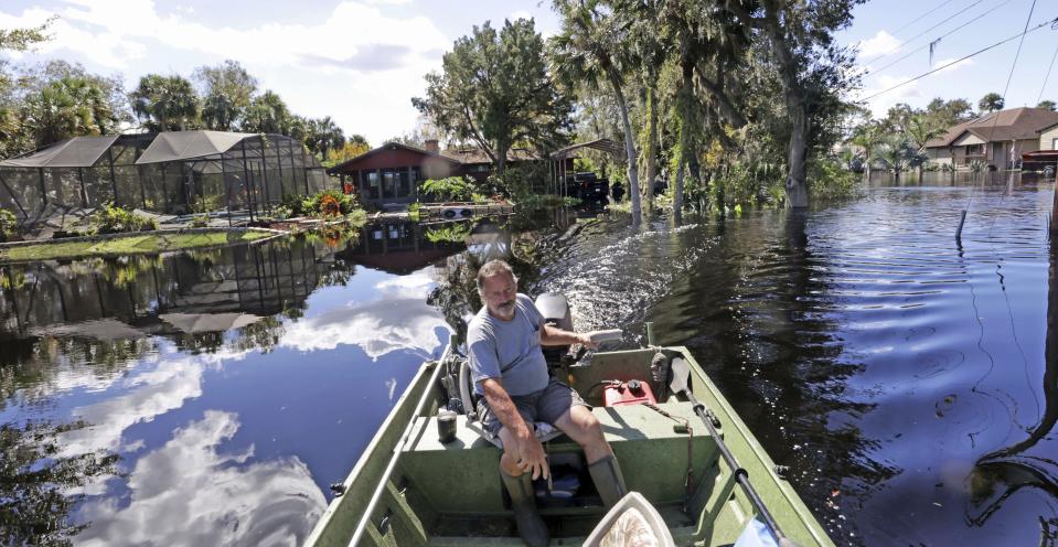 Resident Mike Kelley navigates flooded streets in the Mullet Lake neighborhood, Wednesday, Oct. 5, 2022, in Geneva, Fla., as floodwaters from Lake Harney and the St. Johns River continue to rise following historic levels of rainfall from Hurricane Ian last week. (Joe Burbank/Orlando Sentinel)