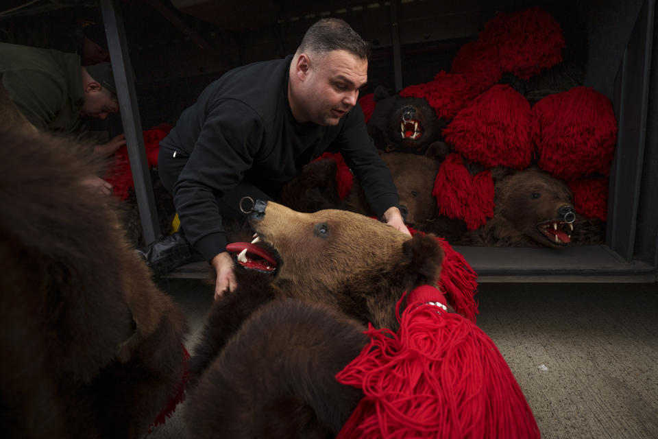 Un integrante del grupo Sipoteni carga trajes de oso en un bus en Comanesti, en el norte de Rumanía, el 26 de diciembre de 2023, antes de recorrer los pueblos de la zona para el tradicional ritual del baile del oso. Hace siglos, quienes vivían en lo que ahora es el noreste de Rumanía se cubrían con pieles de oso y bailaban para ahuyentar a los malos espíritus. Esa costumbre es conocida hoy en día como el Festival del Baile del Oso, que cada diciembre atrae a multitud de turistas. (AP Foto/Andreea Alexandru)