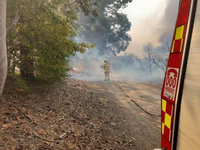 A firefighter battles a bushfire in New South Wales, Australia, August 15, 2018, in this picture obtained from social media. Fire and Rescue NSW/via REUTERS