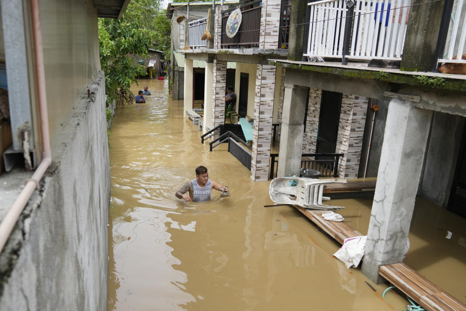 A resident wades through chest-deep floodwater from to Typhoon Noru in San Miguel town, Bulacan province, Philippines, Monday, Sept. 26, 2022. Typhoon Noru blew out of the northern Philippines on Monday, leaving some people dead, causing floods and power outages and forcing officials to suspend classes and government work in the capital and outlying provinces. (AP Photo/Aaron Favila)