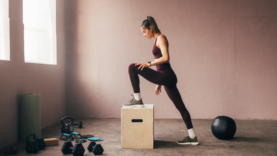 Woman doing step ups onto a box