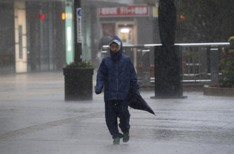 A man walks in heavy rain in Hamamatsu, central Japan, Saturday, Oct. 12, 2019. A heavy downpour and strong winds pounded Tokyo and surrounding areas on Saturday as a powerful typhoon forecast as the worst in six decades approached landfall, with streets and train stations deserted and shops shuttered. (AP Photo/Christophe Ena)