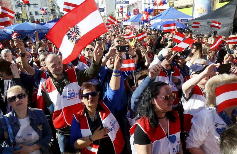 Supporters wave Austrian flags during the final election campaign event of the right-wing Freedom Party (FPOE) for the European elections in Vienna, Friday, May 24, 2024.
