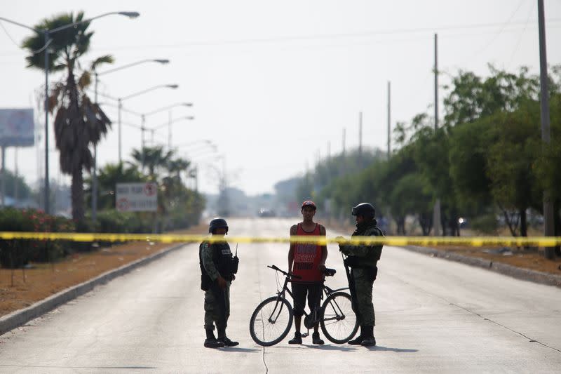 FILE PHOTO: Soldiers talks to a man at a crime scene after unknown assailants attacked a workshop leaving several casualties, according to local media, in Celaya