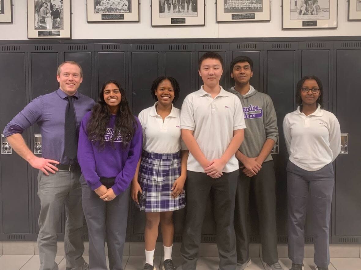 This ethics team at Assumption College Catholic High School is set to participate in the Ontario Ethics Bowl. Jeremy Bracken, left, is head coach of the debate team at the Windsor school. He said these ethics competitions make the students 'better critical thinkers.' (Submitted by Jeremy Bracken - image credit)