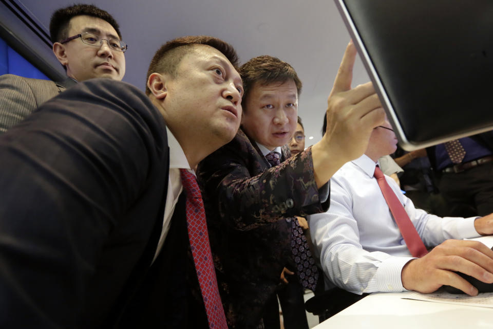 Opera Limited Chairman & CEO Yahui Zhou, third left, with secretary to the board An Da, left, and Shu Guan Wang, from China International Capital Corp., watch price quotes before Opera's IPO begins trading, at the Nasdaq MarketSite, in New York's Times Square, Friday, July 27, 2018. (AP Photo/Richard Drew)