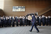 Japan's outgoing Prime Minister Shinzo Abe waves as he leaves the prime minister's office Wednesday, Sept. 16, 2020, in Tokyo. Abe and his Cabinet resigned Wednesday, clearing the way for his successor Yoshihide Suga to take over after parliamentary confirmation later in the day. (AP Photo/Eugene Hoshiko)