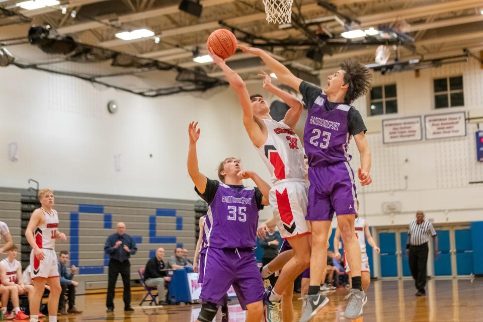 Hammondsport's Ben Dluzak (23) challenges a shot by Canisteo-Greenwood's Sage Klees Saturday in the Steuben County Tournament semifinals. C-G prevailed, 77-53.