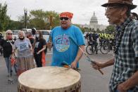 Indigenous men play a drum and sing during an act of civil disobedience during a climate change protest including indigenous and youth activists, Friday, Oct. 15, 2021, near the U.S. Capitol in Washington. (AP Photo/Jacquelyn Martin)