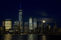 <p>A full moon rises above the New York skyline and the Hudson River, May 10, 2017, seen from Jersey City, N.J. One World Trade Center towers above the other buildings. (Photo: Mark Lennihan/AP) </p>