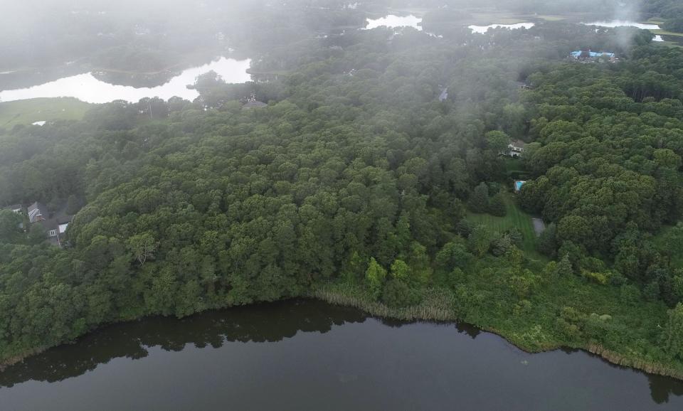 An aerial view shows Bog Pond in Osterville looking toward an undeveloped four-acre parcel, center of the photo, at 39 Fox Island Road in Osterville. The land has been donated to the Osterville Village Library, which plans to sell the land to bolster the library's endowment fund.