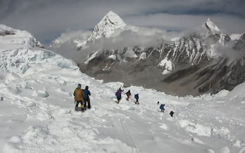 In this file photo taken on April 29, 2018, mountaineers walk near camp one of Mount Everest, as they prepare to ascend on the south face from Nepal. - Credit: Phunjo Lama/AFP