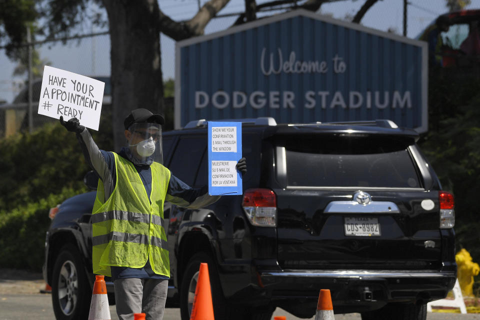 Workers direct cars as they wait in line for coronavirus testing at Dodger Stadium on Tuesday, July 14, 2020, in Los Angeles. / Credit: Mark J. Terrill / AP