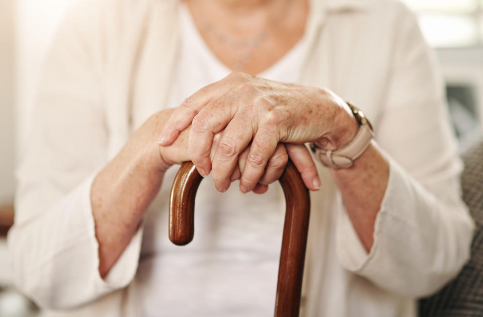 Cropped shot of a senior woman using a walking stick at home