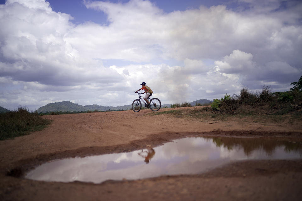 A youth rides a bicycle through the village of Wowetta, located in the Essequibo, Guayana, Saturday, Nov. 18, 2023. Venezuela has long claimed Guyana’s Essequibo region — a territory larger than Greece and rich in oil and minerals. (AP Photo/Juan Pablo Arraez)