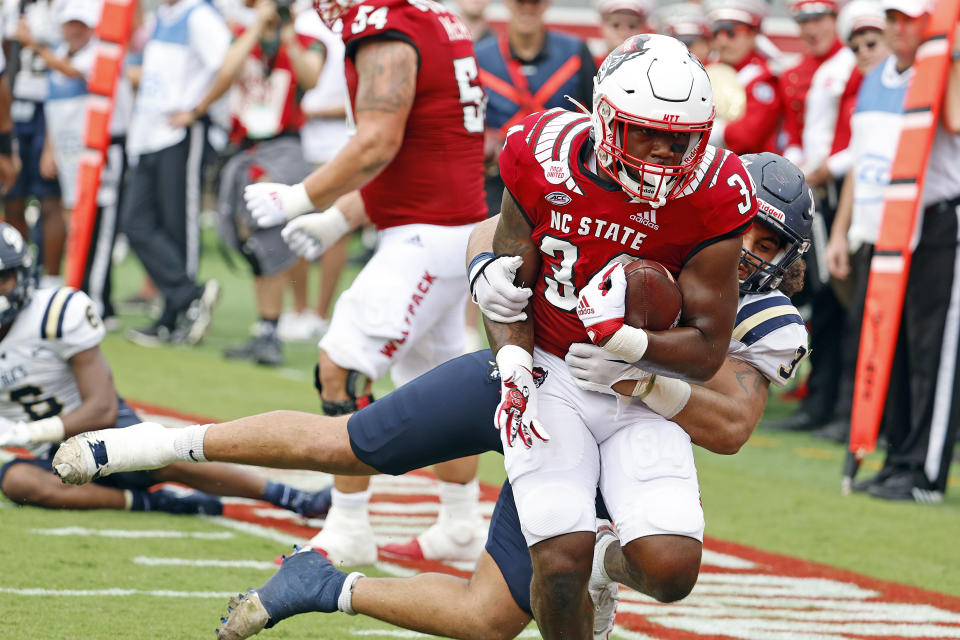 North Carolina State's Delbert Mimms III (34) drags Charleston Southern's Quintin Seguin (3) into the end zone for a touchdown during the first half of an NCAA college football game in Raleigh, N.C., Saturday, Sept. 10, 2022. (AP Photo/Karl B DeBlaker)