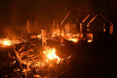 FILE PHOTO: Flames from the Ponderosa Fire burn a home east of Oroville, California, U.S. August 29, 2017. REUTERS/Noah Berger/File Photo