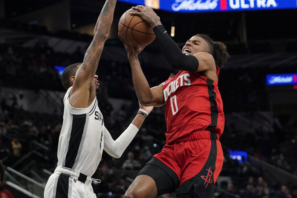 Houston Rockets guard Jalen Green (0) drives to the basket against San Antonio Spurs guard Dejounte Murray (5) during the first half of an NBA basketball game, Wednesday, Jan. 12, 2022, in San Antonio. (AP Photo/Eric Gay)