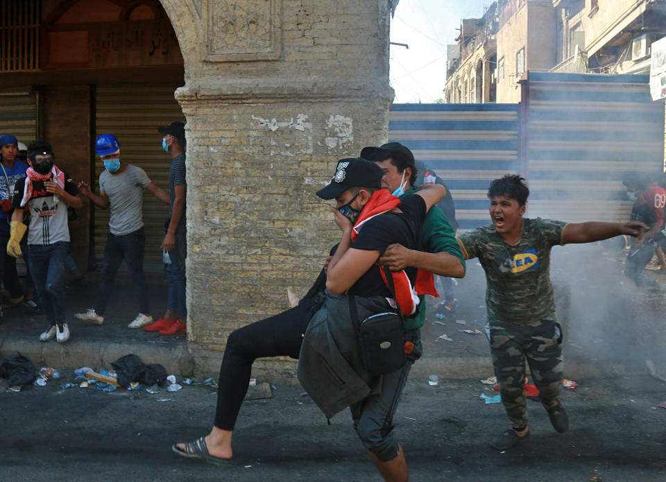 An injured protester is rushed to a hospital during clashes between Iraqi security forces and anti-government protesters in the al-Rasheed street in Baghdad, Iraq, Friday, Nov. 8, 2019. The demonstrators complain of widespread corruption, lack of job opportunities and poor basic services, including regular power cuts despite Iraq's vast oil reserves. They have snubbed limited economic reforms proposed by the government, calling for it to resign. (AP Photo/Khalid Mohammed)