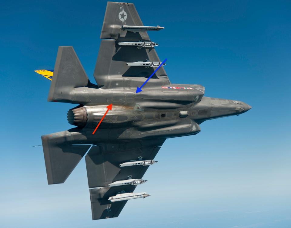 An annotated photo of an F-35C, showing the dual flip-open infrared countermeasures dispenser door (blue arrow) and the towed decoy deployment door located just aft of it (red arrow). <em>Lockheed Martin</em><br>