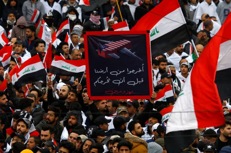 Supporters of Iraqi Shi'ite cleric Moqtada al-Sadr hold a sign reading "Get out of our land before you leave defeated" at a protest against what they say is U.S. presence and violations in Iraq, in Baghdad