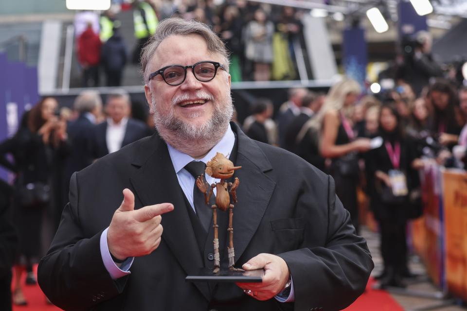 Director Guillermo del Toro poses, with a model of the character Pinocchio, for photographers upon arrival for the premiere of the film 'Guillermo del Toro's Pinocchio' during the 2022 London Film Festival in London, Saturday, Oct. 15, 2022. (Photo by Vianney Le Caer/Invision/AP)